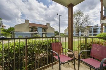 Two red chairs are on a patio.